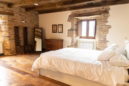 a bedroom with a bed and a brick wall at CASA GRANDE VILAR in Vilar