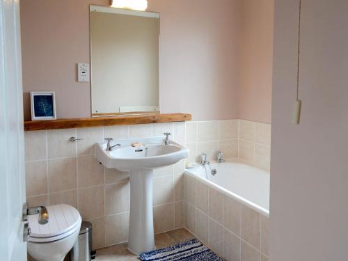 a bathroom with a sink and a tub and a toilet at Morlich in Gairloch