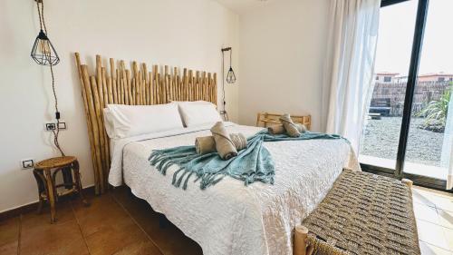 1 dormitorio con cama y ventana grande en AliNico House Majanicho iRent Fuerteventura, en La Oliva