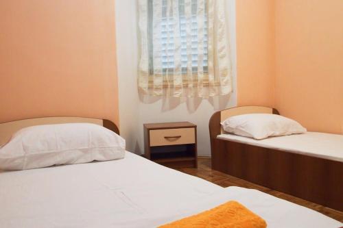 - 2 lits dans une petite chambre avec fenêtre dans l'établissement Comfortable Apartment 6+2, à Makarska