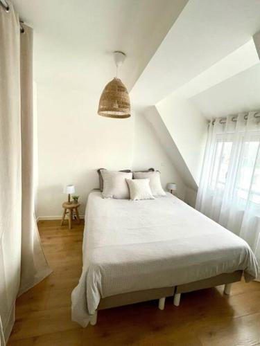 - une chambre blanche avec un grand lit et des draps blancs dans l'établissement Appartement deux chambres mer a 150m, à Berck-sur-Mer