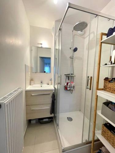une salle de bain blanche avec une douche et un lavabo dans l'établissement Appartement deux chambres mer a 150m, à Berck-sur-Mer