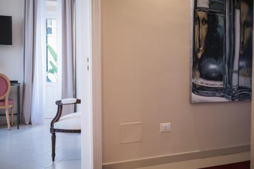 a room with a chair and a picture on the wall at Aria Rooms and Terrace in Noto