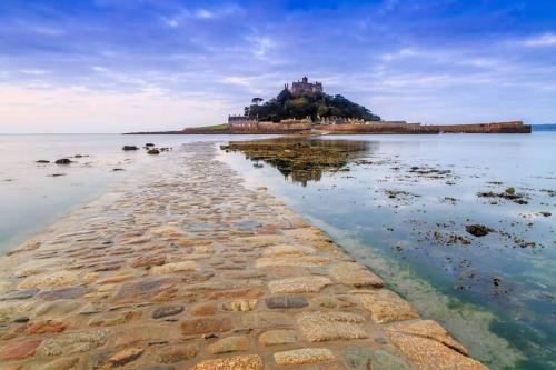 an island in the water with a castle on it at Cosy country getaway, 5 mins from the sea in Penzance