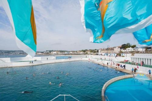 a swimming pool with people in the water at Cosy country getaway, 5 mins from the sea in Penzance