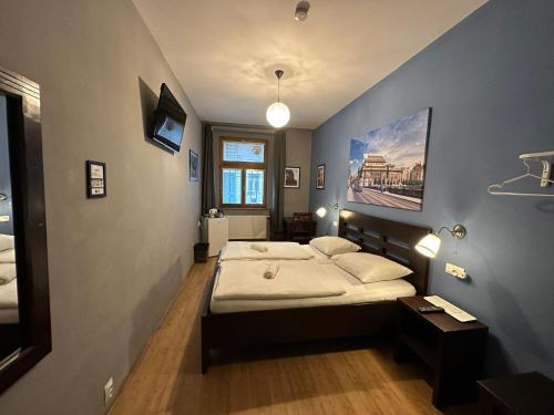 um quarto com uma cama e uma parede azul em Central Studios em Praga