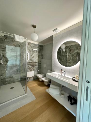 a bathroom with two toilets and a sink and a shower at C House Rooms Lake in Peschiera del Garda
