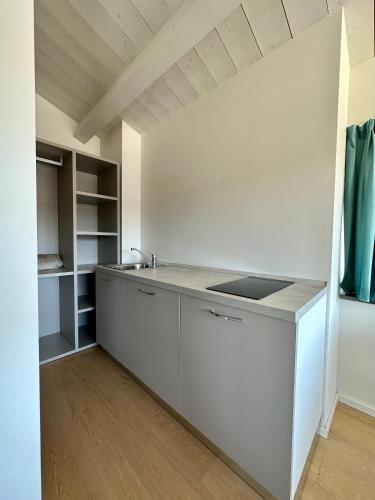 a kitchen with white cabinets and a sink at C House Rooms Lake in Peschiera del Garda
