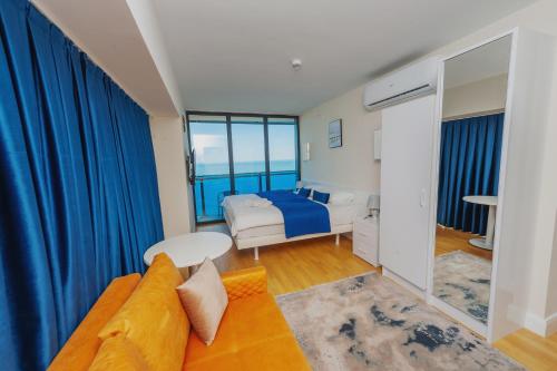 ORBI CITY SUITE في باتومي: غرفة معيشة مع سرير وأريكة