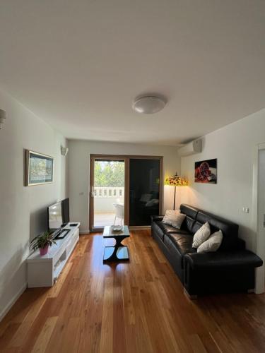 a living room with a black couch and a table at Apartman Ambasador in Makarska