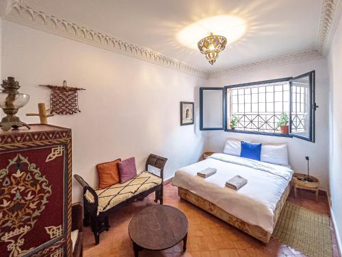 a bedroom with a bed and a chair and a window at Imsouane Surf Paradise in Imsouane