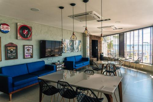 salon z niebieskimi kanapami, stołami i krzesłami w obiekcie Lake Side Apart Hotel w mieście Brasília