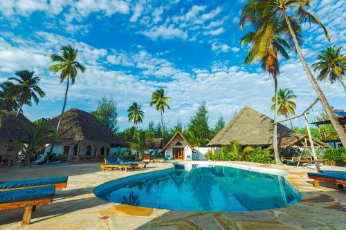 a resort with a swimming pool and palm trees at Emerald Dreams Boutique Hotel in Michamvi