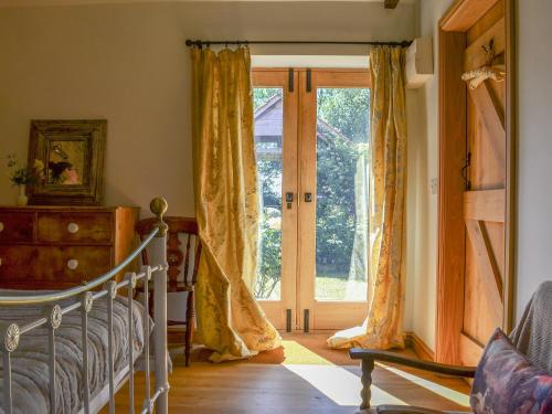 ドッグダイクにあるCornflower Cottage Ukc1897のベッドルーム1室(ベッド1台付)、スライド式ガラスドアが備わります。
