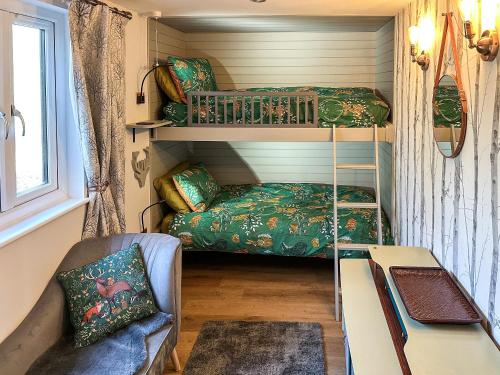 ein winziges Haus mit einem Etagenbett und einer Couch in der Unterkunft Talltrees - Uk42842 in Uplowman