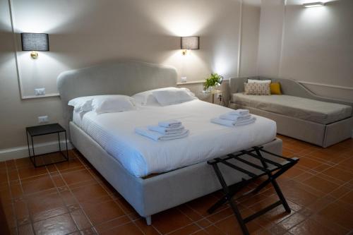 een slaapkamer met een groot wit bed en een bank bij CASA ALMIKA PRINCIPE AMEDEO in Bari