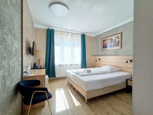 a hotel room with a bed and a chair at Kamienica Morska Gdynia in Gdynia