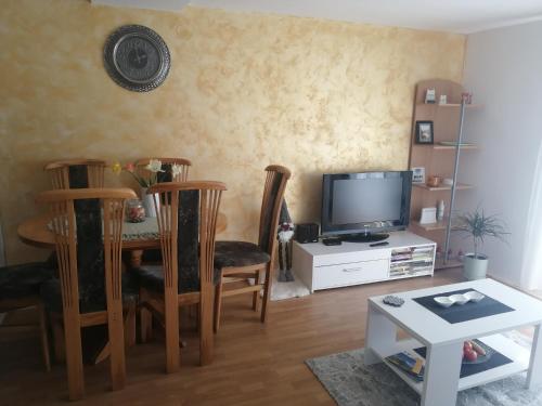 sala de estar con mesa y TV en Vikendica Lep pogled en Rtanj