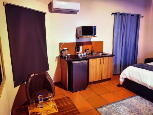 a hotel room with a bed and a table and a chair at Lipizzaner Lodge - Kyalami, Midrand in Kyalami