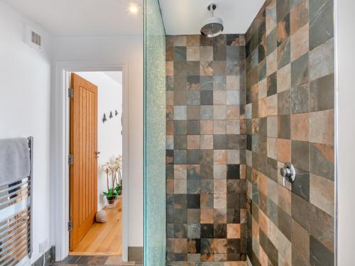 bagno con doccia e parete piastrellata di Pebble Cottage a Cullercoats