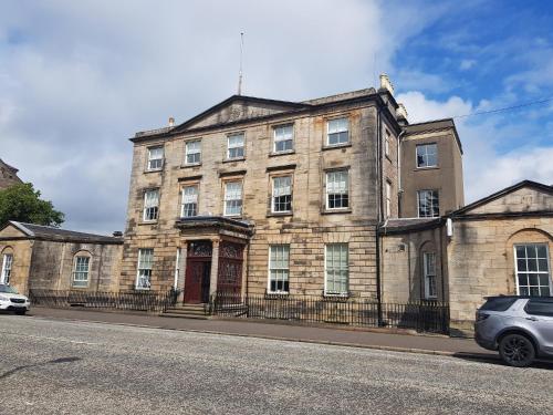 an old brick building on the side of a street at The Tontine Hotel in Greenock