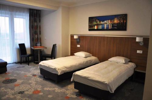 pokój hotelowy z dwoma łóżkami i stołem w obiekcie Hotel Europa w Lubinie