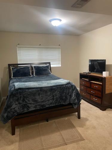 een slaapkamer met een bed, een dressoir en een televisie bij Sunshine’s Nest in Knoxville