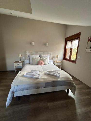 a bedroom with a large bed with two tables and a window at L'ECRIN DU LAC chambres d'hôtes in Saint-Point-Lac
