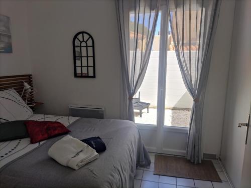 a bedroom with a bed and a large window at Villa émeraude dans résidence in Cap d'Agde