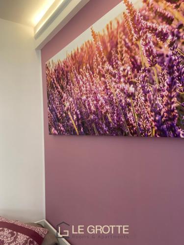 a painting of a field of purple flowers on a wall at Affittacamere Le Grotte - Le Grotte Rooms & Apartments in Camerano