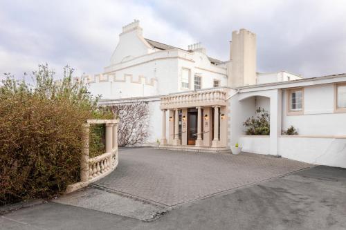 an exterior view of a white house with a driveway at North West Castle Hotel in Stranraer