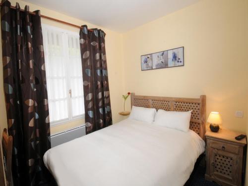 a bedroom with a white bed and a window at Hotel La Cabane in Belin-Beliet