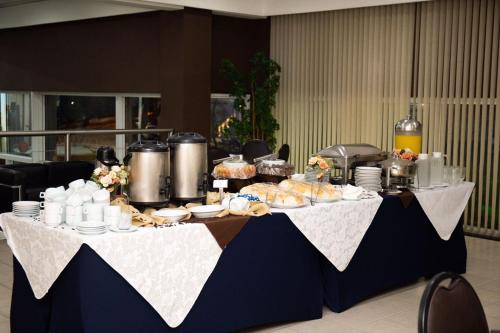a table with food and drinks on top of it at Sables Hotel Guarulhos in Guarulhos