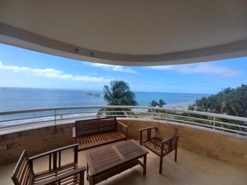 a balcony with benches and a view of the ocean at Beach View Palace in Porlamar