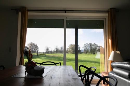 a dining room table with a view of a field at Côté Jardin in Buvrinnes