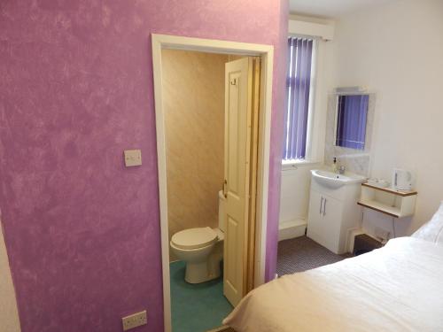 a small bathroom with a toilet and a sink at Llanryan Guest House in Blackpool