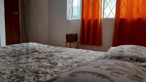 Schlafzimmer mit einem Bett, roten Vorhängen und einem Fenster in der Unterkunft Habitación privada cama doble baño compartido in Bogotá