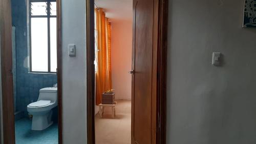eine offene Tür zu einem Bad mit WC in der Unterkunft Habitación privada cama doble baño compartido in Bogotá