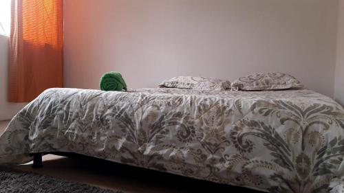 ein Bett mit einer grauen und weißen Bettdecke und Kissen in der Unterkunft Habitación privada cama doble baño compartido in Bogotá