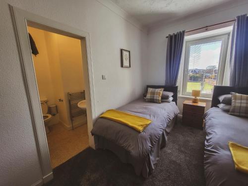 a small room with two beds and a window at THE EARN HOTEL in Bridge of Earn