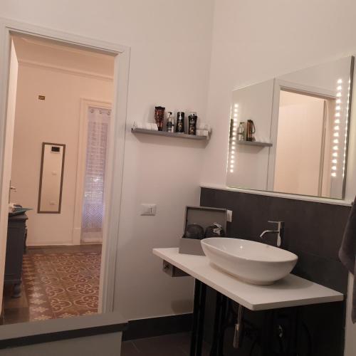 a bathroom with a white sink and a mirror at Opera Prima 28 in Palermo