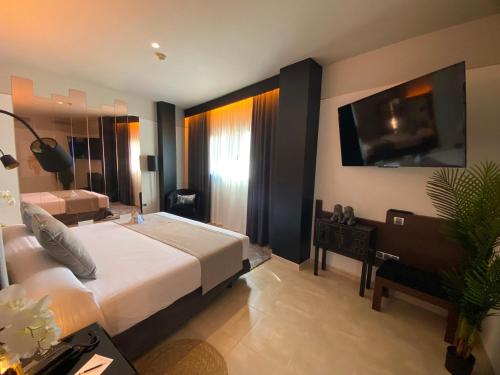 a hotel room with a large bed and a television at ON ALETA ROOM designed for adults in Almuñécar