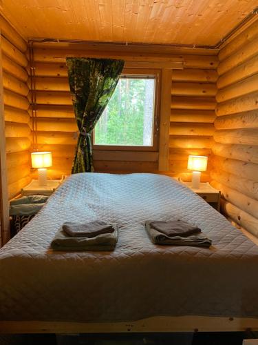 Un dormitorio con una cama con dos zapatos. en Mökki järven rannalla mäntymetsässä en Forssa