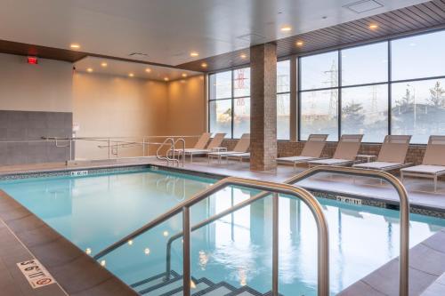 a swimming pool in a building with chairs at Residence Inn by Marriott San Francisco Airport Millbrae Station in Millbrae