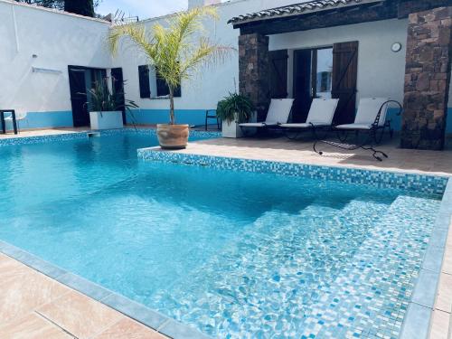 a swimming pool with blue water in front of a house at Le Patio Bleu in La Crau