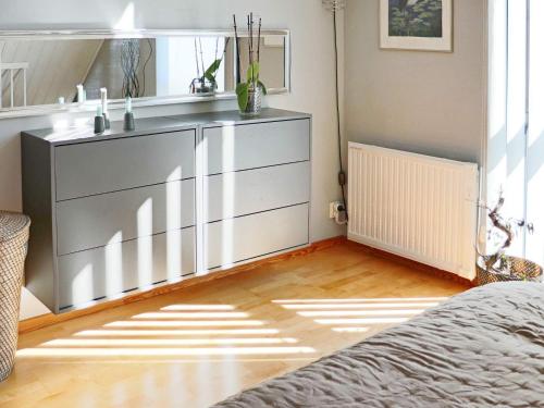 een slaapkamer met een dressoir en een spiegel bij Holiday home Förslöv in Förslöv