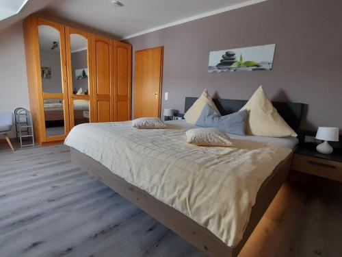 Apartment in Kleines Wiesental, Sallneck في Sallneck: غرفة نوم بسرير كبير عليها شراشف ووسائد بيضاء