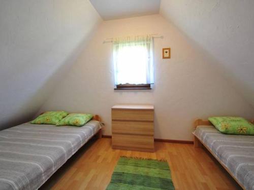 Camera mansardata con 2 letti e finestra. di Domki letniskowe Pod brzozą a Nowęcin