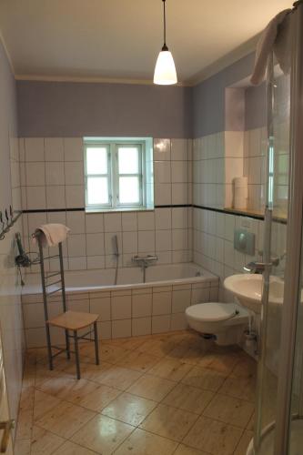 uma casa de banho com uma banheira, um WC e um lavatório. em Altes Waschhaus Krakvitz em Putbus
