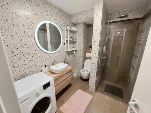 een badkamer met een douche, een wastafel en een wasmachine bij Ozzy Cozy in Zagreb